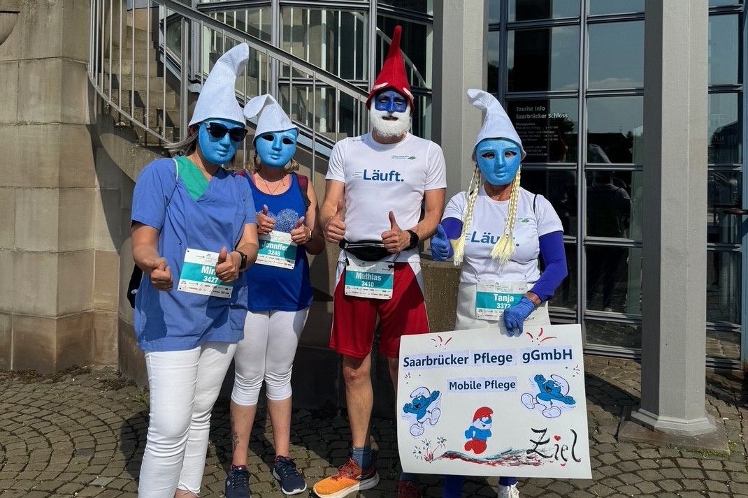 Mitarbeitende der Mobilen Pflege gemeinsam mit dem Geschäftsführer Matthias Mudra beim Firmenlauf 2025 verkleidet als Schlümpfe