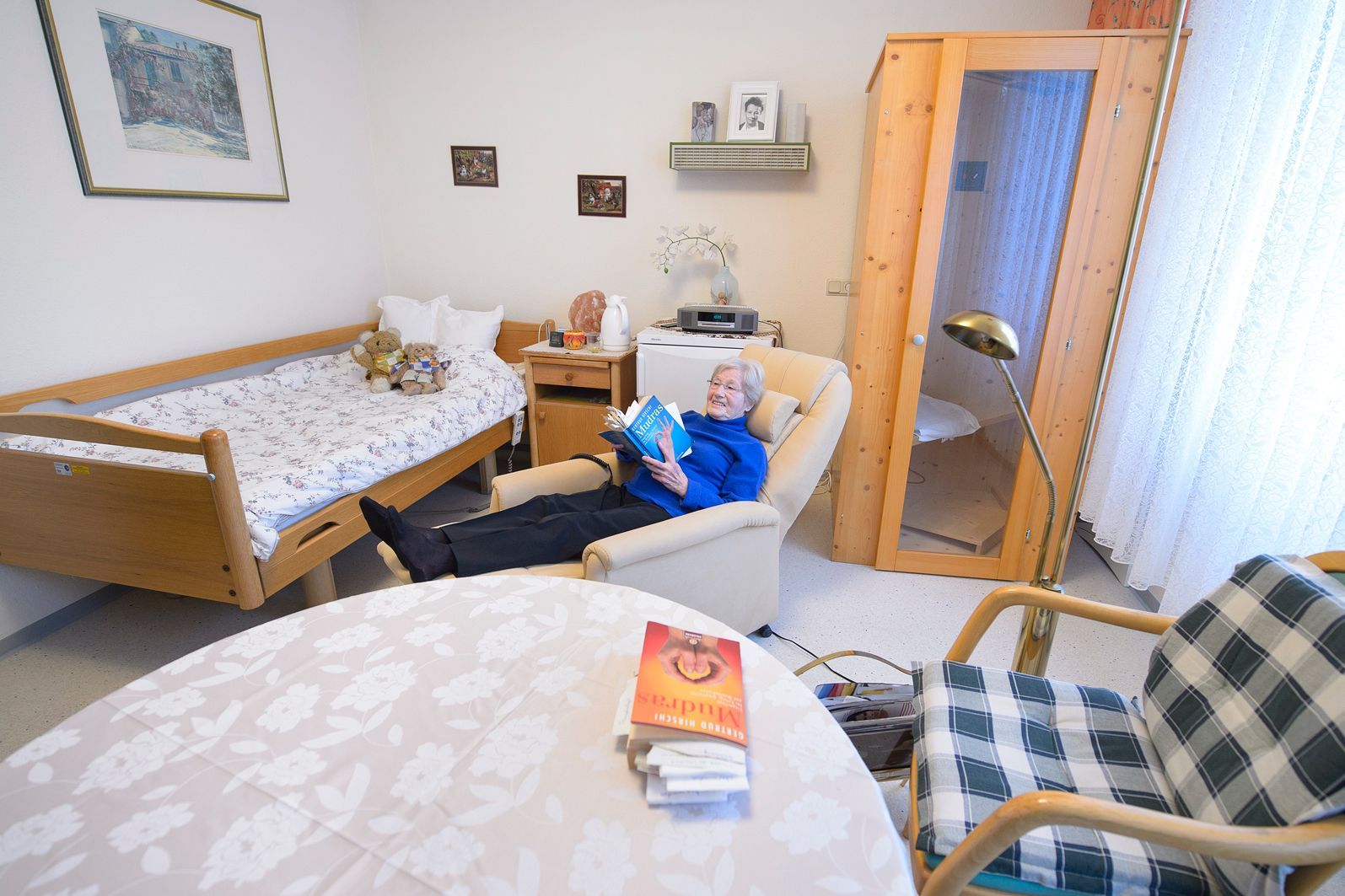 Frau Käfer entspannt beim Lesen im Sessel.